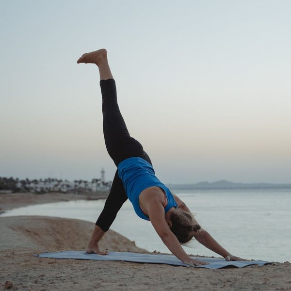 Woman in a peaceful yoga pose against a calm background.